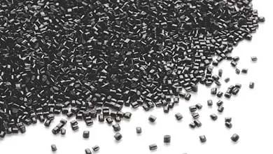 Close-up of black plastic granules scattered on a white background.